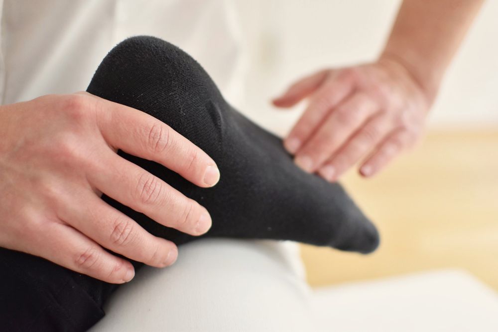 Nahaufnahme: Hände am bekleideten Fuß